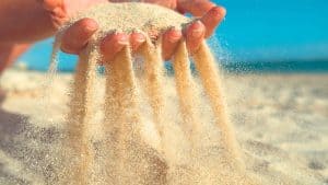 Image of sand falling through a person's hands, representing kids slipping through the cracks