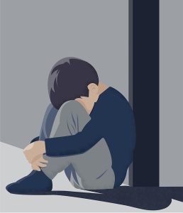 Image of a sad child sitting in a corner